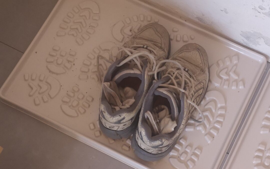 Robuste Wanderschuhe auf einer Schuhmatte, bereit für eine Fastenwanderung in Brandenburg.